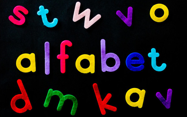 Färgade bokstäver mot svart bakgrund där några av bokstäverna bildar ordet "alfabet".