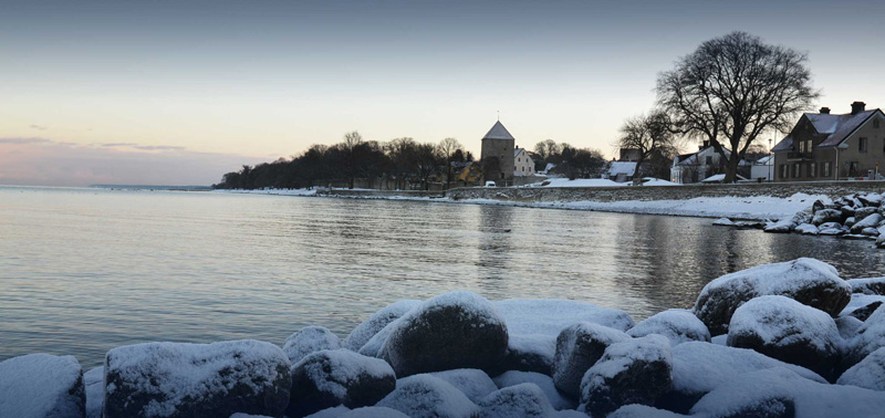Kruttornet i Visby med havet framför och snö på marken.