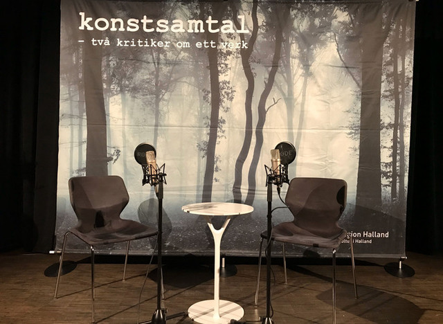 Scenen står redo för konstsamtal med två stolar och två mikrofoner.