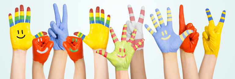 Barnhänder täckta med målarfärg i olika kulörer.