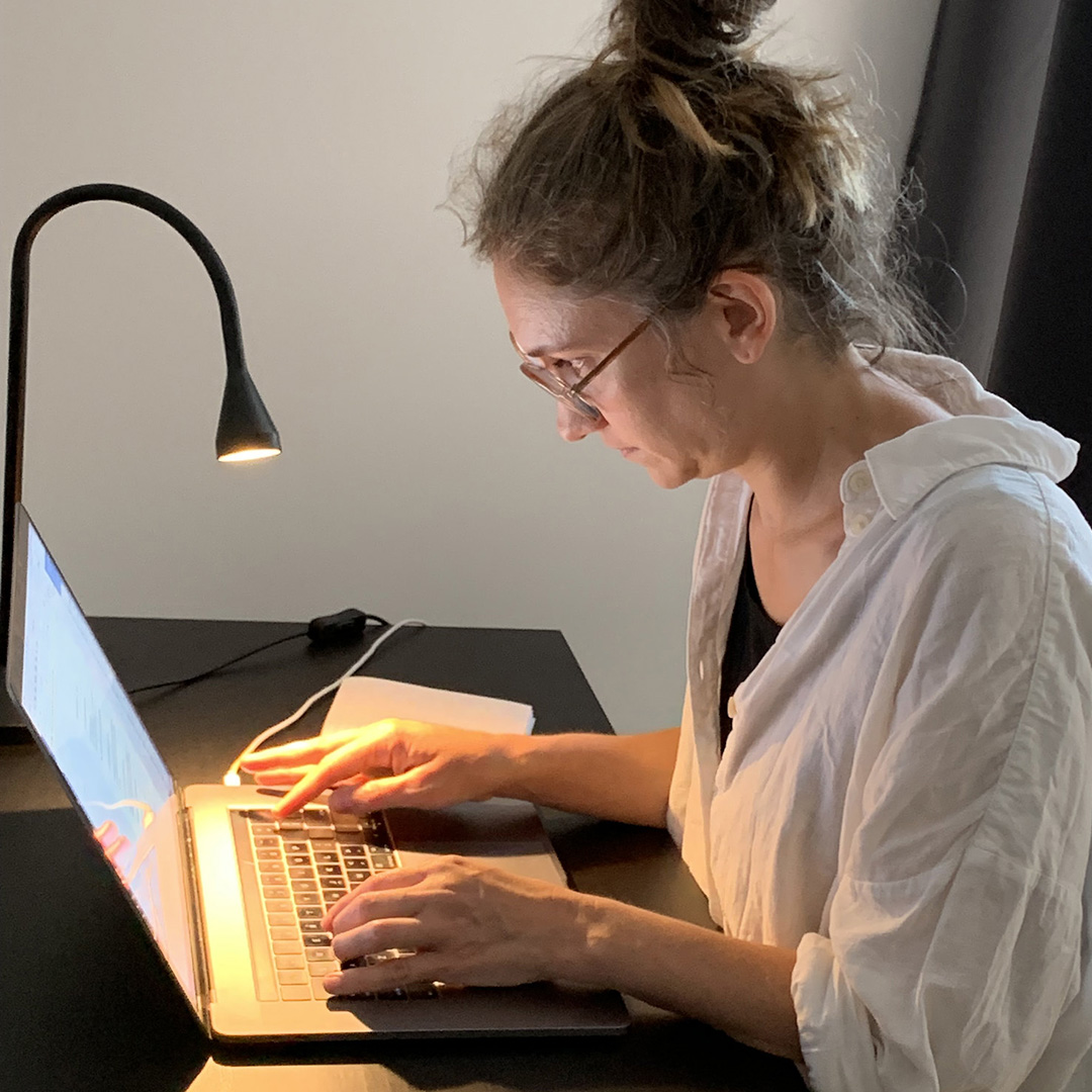 Författaren Krystallia Sakellariou sitter vid sin dator och skriver.