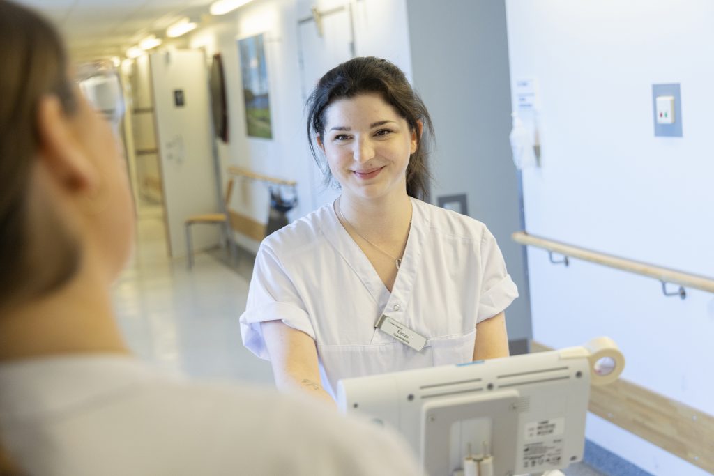 Sjuksköterskan Elinour står i en sjukhuskorridor