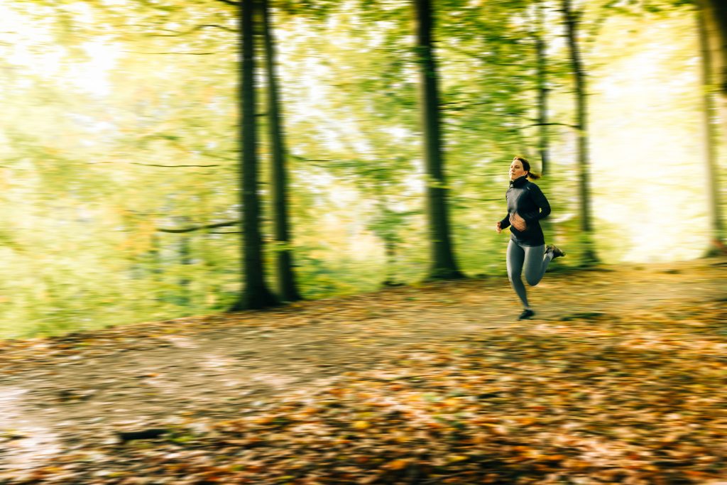 Kvinna springer i skogen