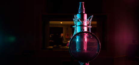 En mikrofon i en svagt upplyst inspelningsstudio.