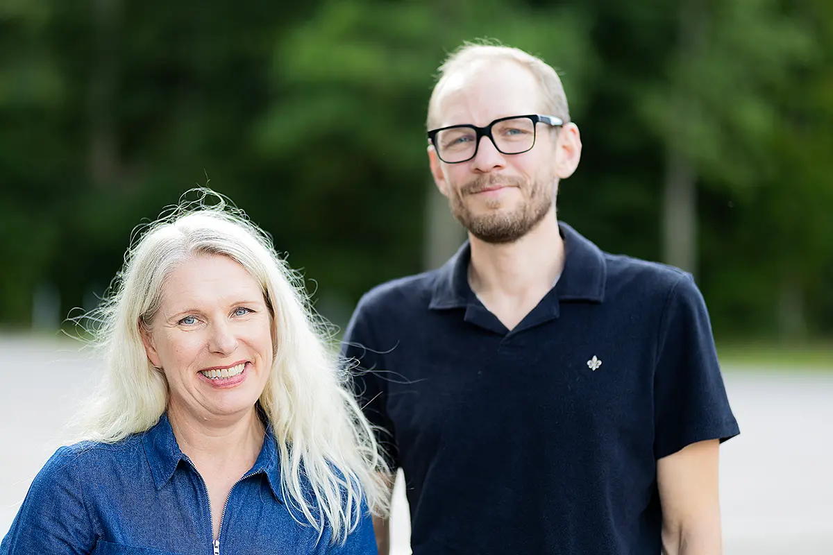 En man och en kvinna står bredvid varandra och ler