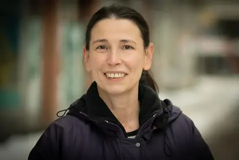 En leende kvinna i mörk jacka.