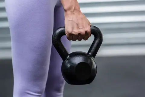 Person som håller en kettlebell.